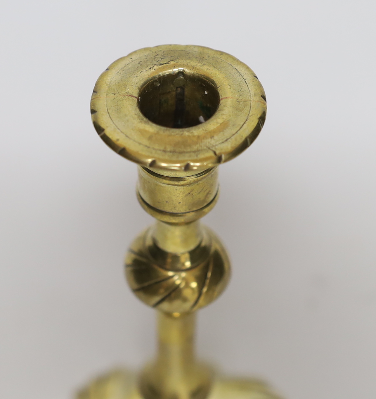 A mid 18th century swirl base brass candlestick, 21cm